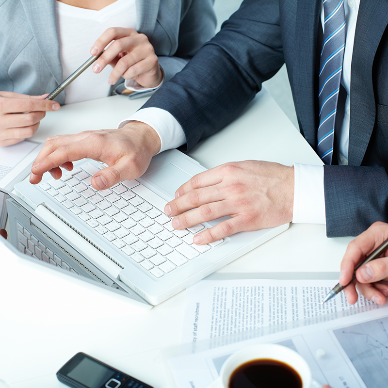Business professional reviewing commercial account invoices on a laptop